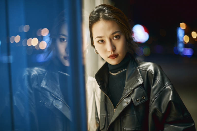 夜晚站立在橱窗外的亚洲少女图片