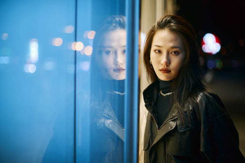 夜晚站立在橱窗外的亚洲少女图片