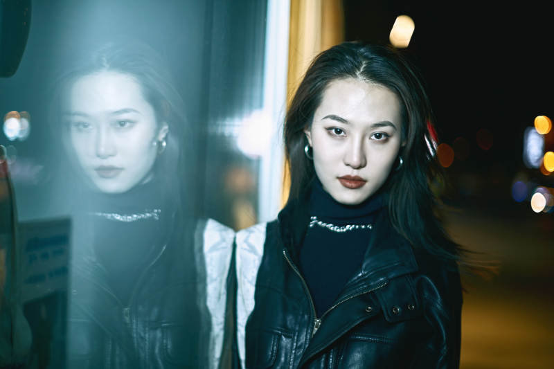 夜晚站立在橱窗外的亚洲少女图片