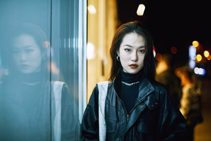 夜晚站立在橱窗外的亚洲少女图片