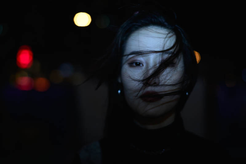 夜晚站立在橱窗外的亚洲少女图片