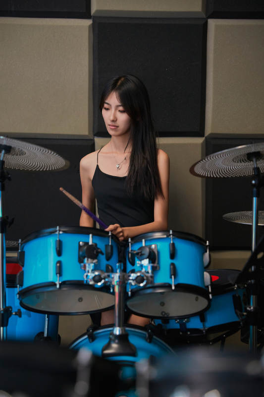 在排练室打爵士鼓的亚洲少女图片