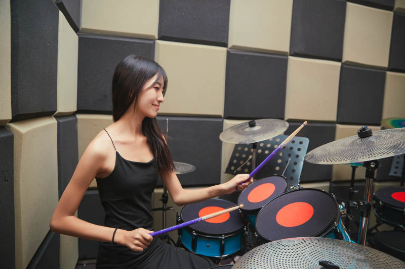 在排练室打爵士鼓的亚洲少女图片