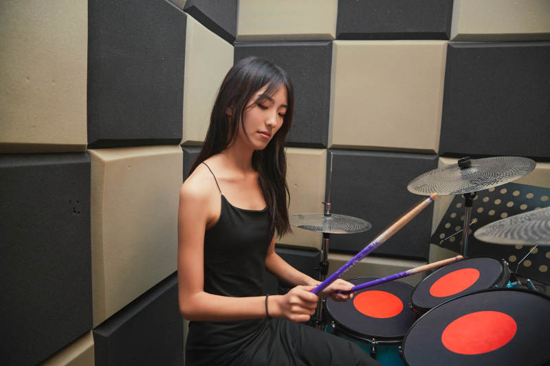 在排练室打爵士鼓的亚洲少女图片