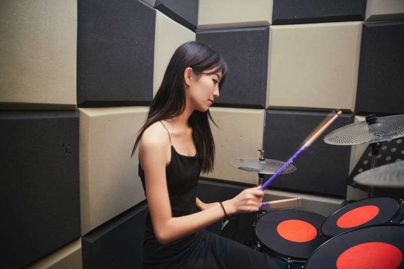在排练室打爵士鼓的亚洲少女图片