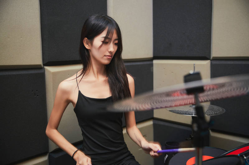 在排练室打爵士鼓的亚洲少女图片