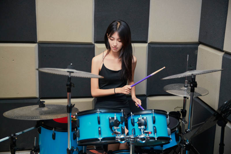 在排练室打爵士鼓的亚洲少女图片