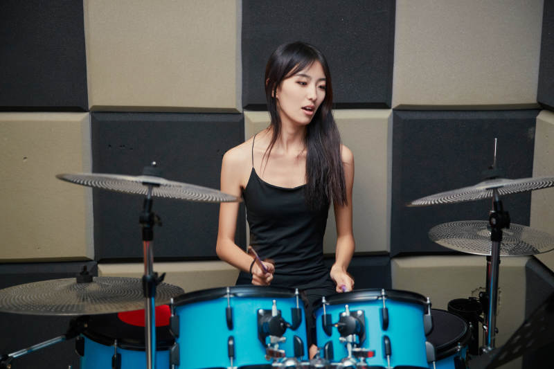 在排练室打爵士鼓的亚洲少女图片