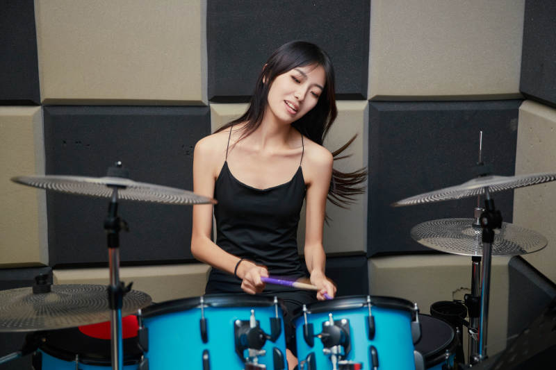 在排练室打爵士鼓的亚洲少女图片