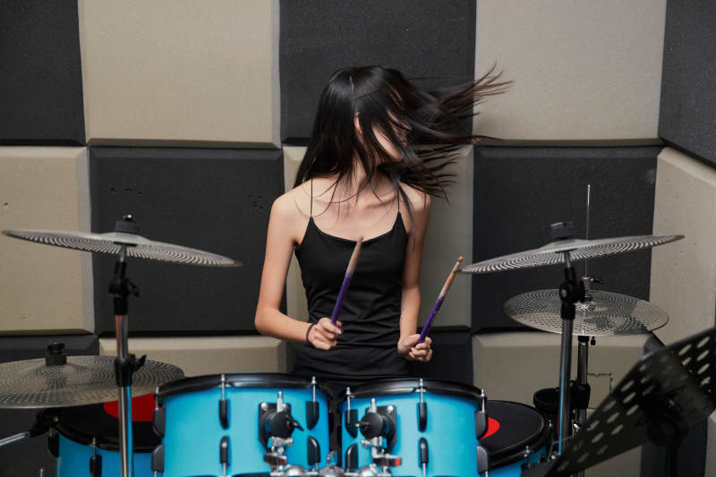 在排练室打爵士鼓的亚洲少女图片