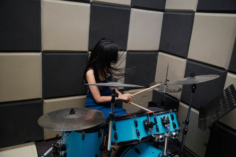 在排练室打爵士鼓的亚洲少女图片