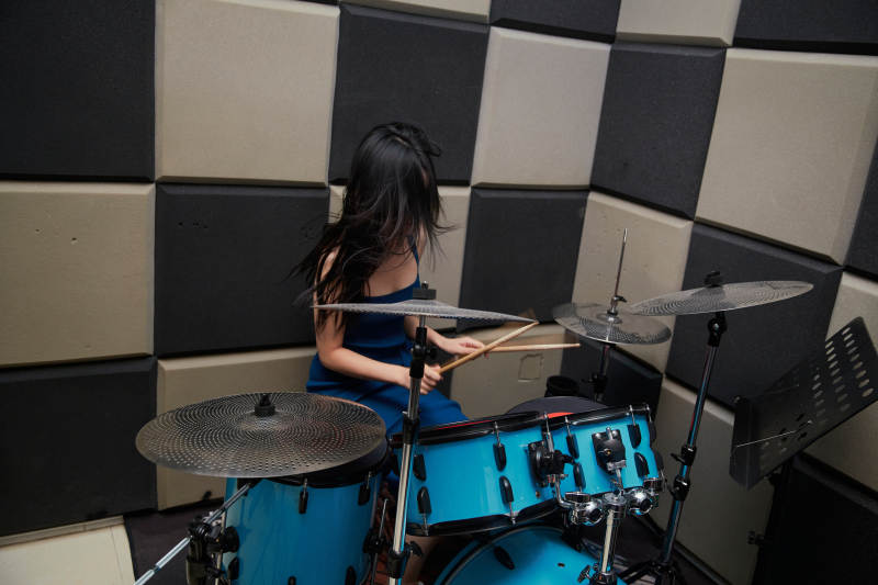 在排练室打爵士鼓的亚洲少女图片