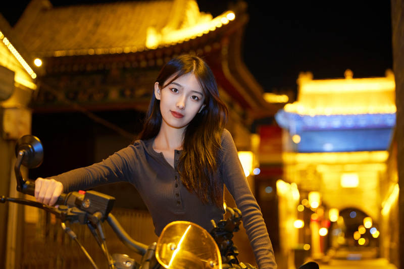夜晚古城景区骑摩托的少女图片