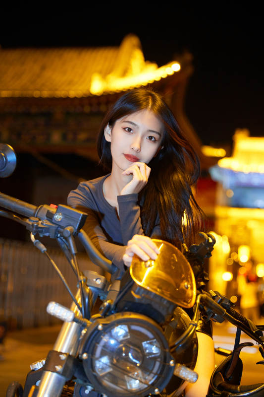 夜晚古城景区骑摩托的少女图片