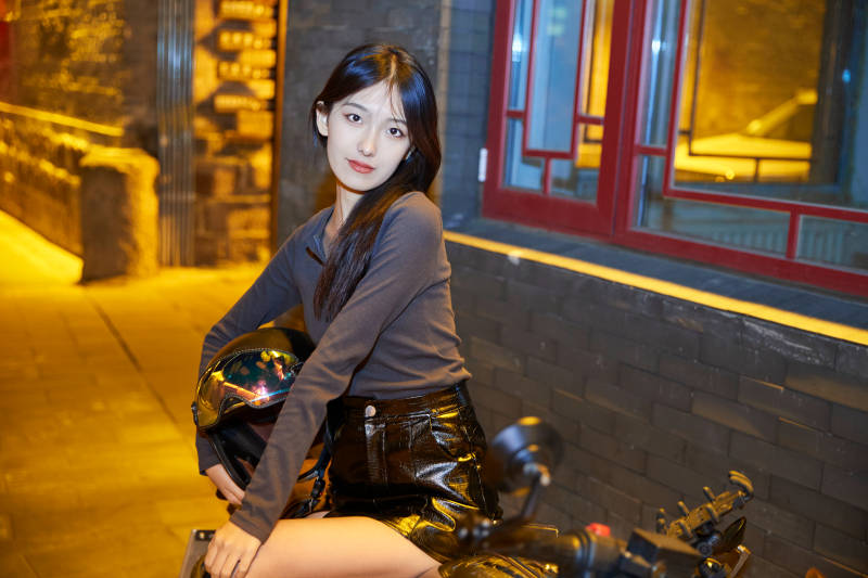 夜晚古城景区骑摩托的少女图片