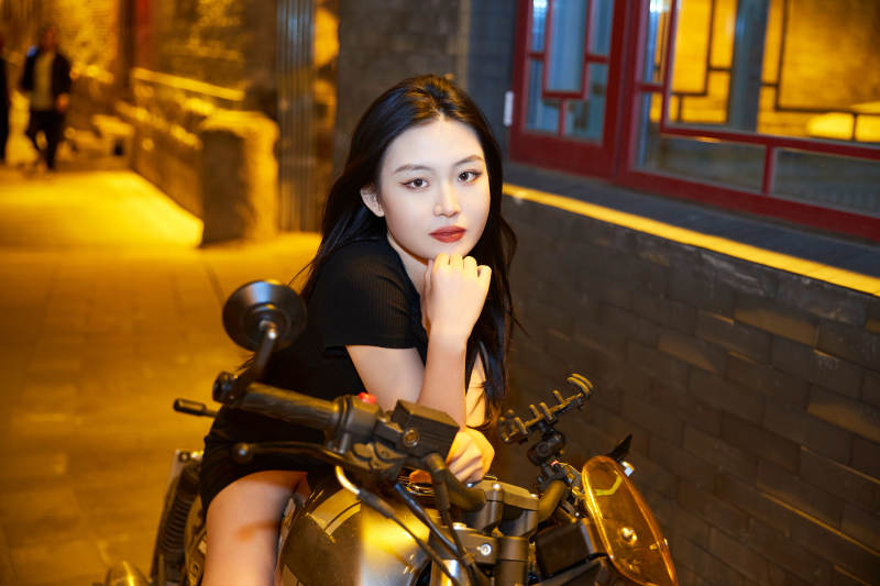 夜晚古城景区骑摩托的少女图片