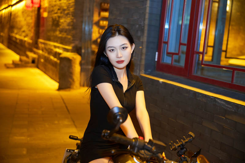 夜晚古城景区骑摩托的少女图片
