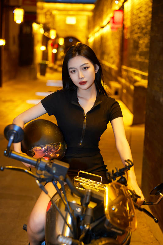 夜晚古城景区骑摩托的少女图片