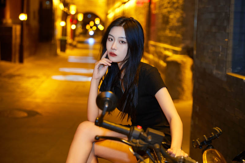 夜晚古城景区骑摩托的少女图片