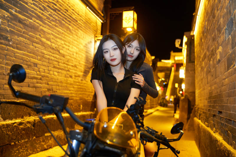 夜晚古城景区骑摩托的少女图片