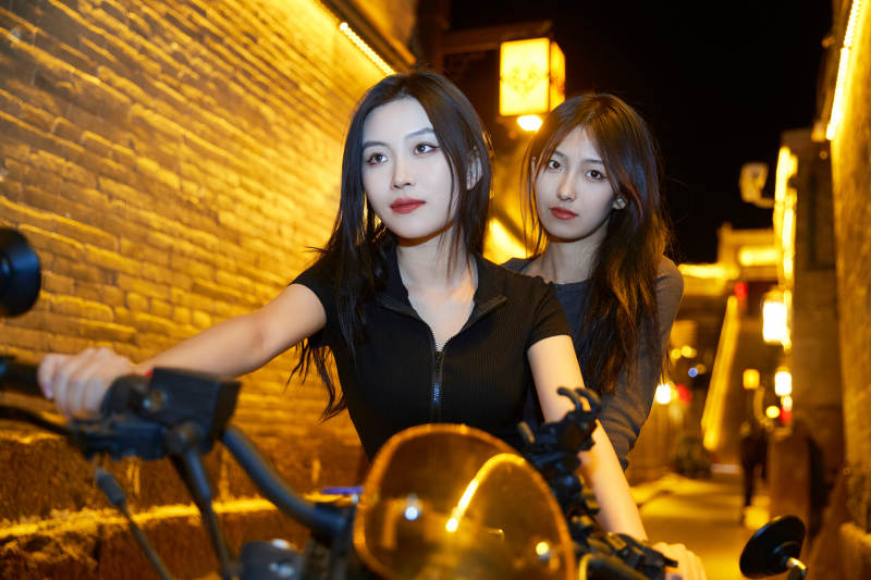 夜晚古城景区骑摩托的少女图片