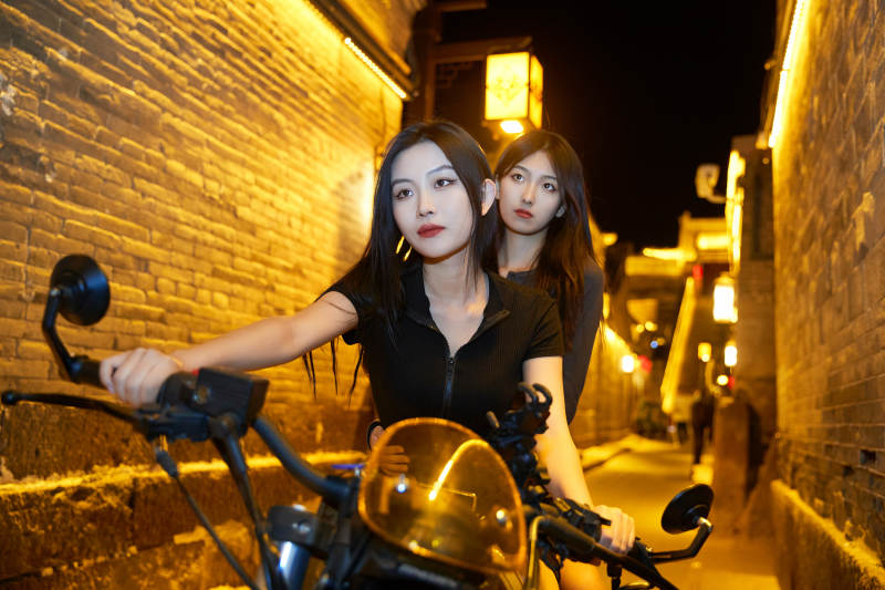 夜晚古城景区骑摩托的少女图片