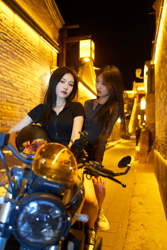 夜晚古城景区骑摩托的少女图片