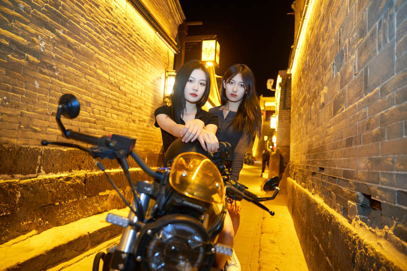 夜晚古城景区骑摩托的少女图片