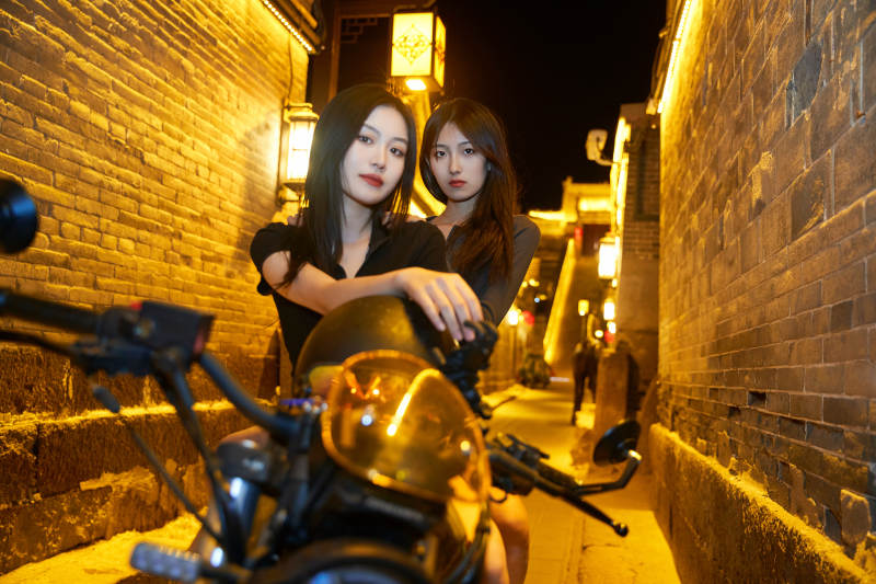 夜晚古城景区骑摩托的少女图片