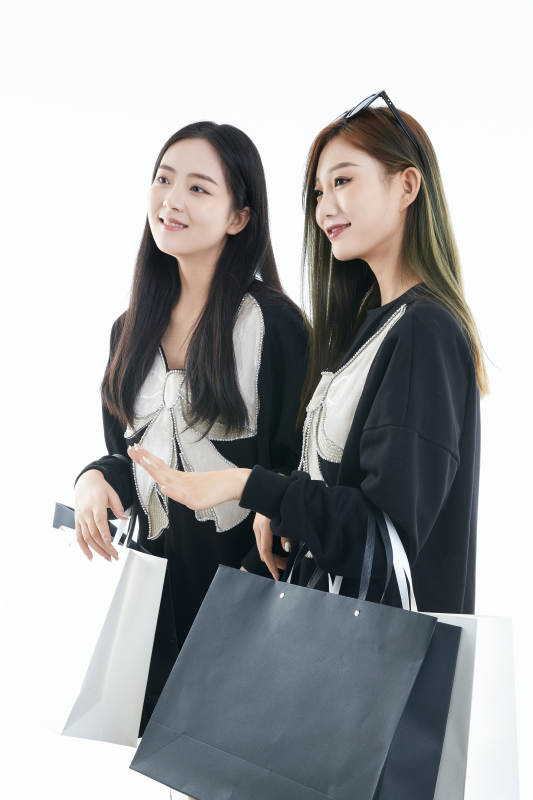 白色背景下手提购物袋时尚美丽的闺蜜图片