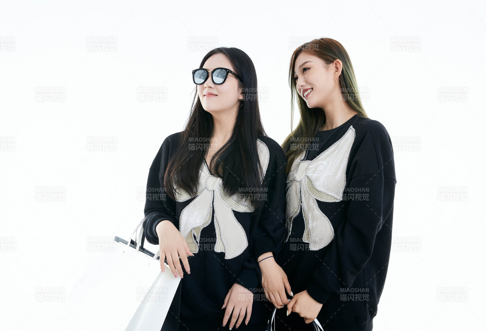 白色背景下手提购物袋时尚美丽的闺蜜图片