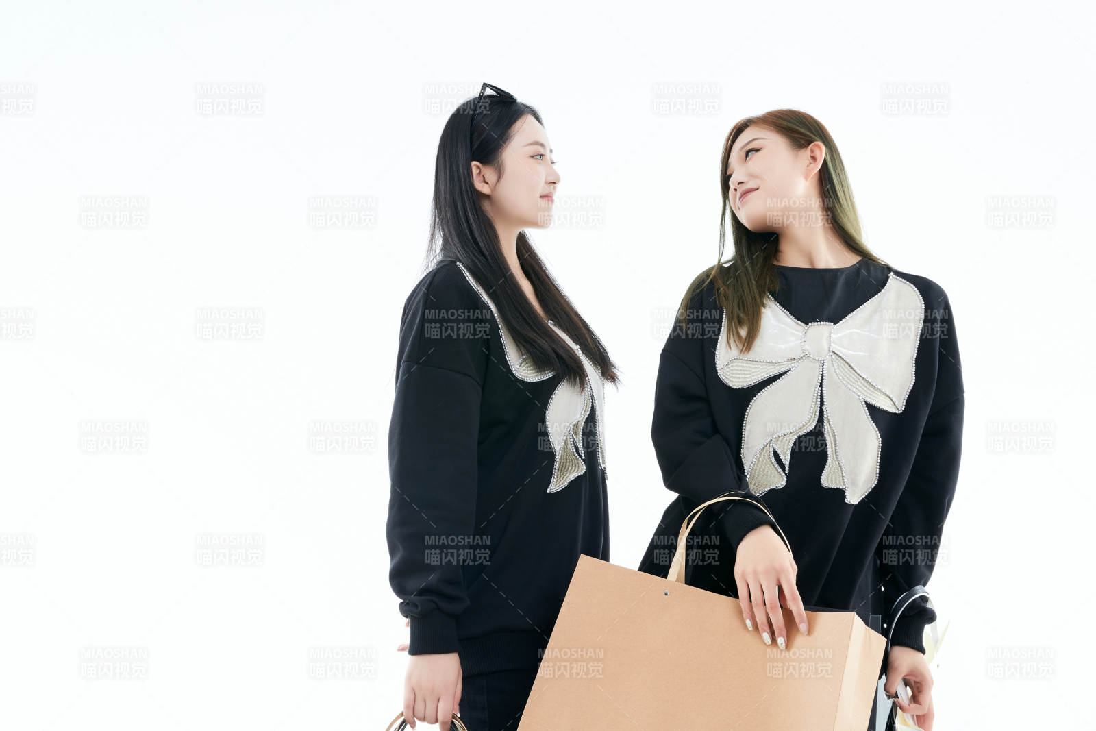 白色背景下手提购物袋时尚美丽的闺蜜图片