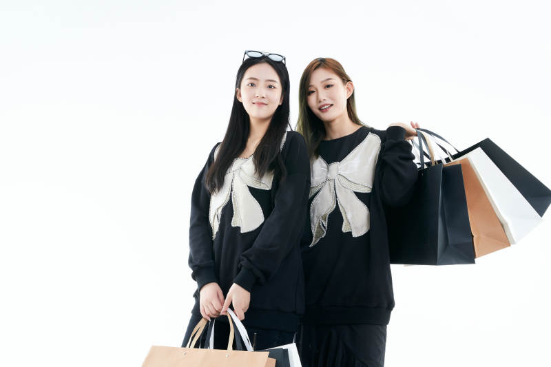 白色背景下手提购物袋时尚美丽的闺蜜图片