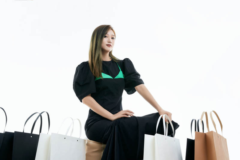 白色背景下手提购物袋时尚美丽的亚洲少女图片