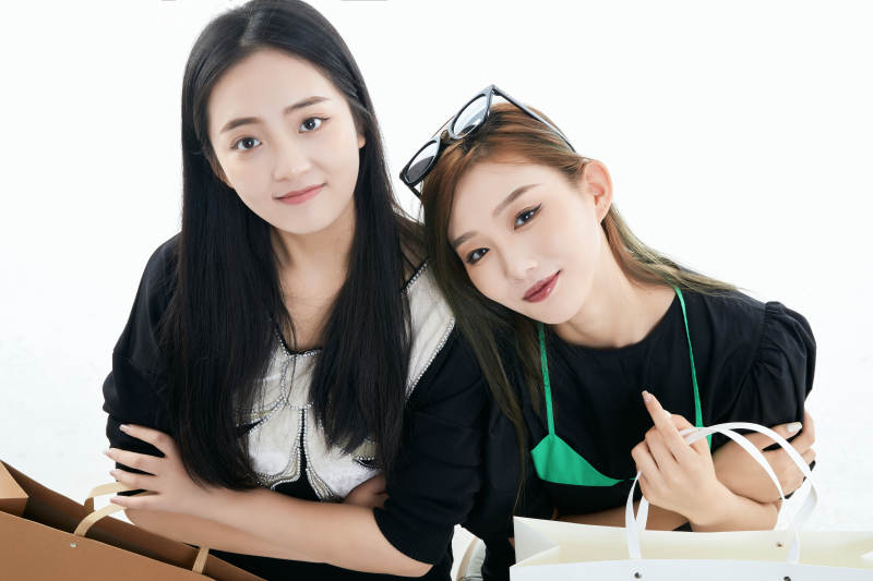 白色背景下手提购物袋时尚美丽的闺蜜图片