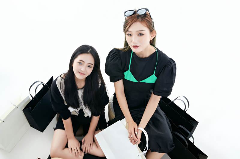 白色背景下手提购物袋时尚美丽的闺蜜图片