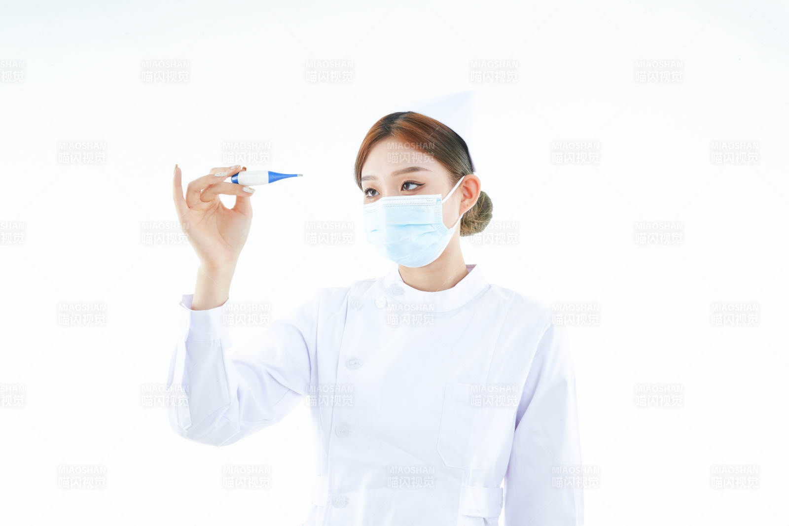 手持温度计的白衣女性医护人员图片