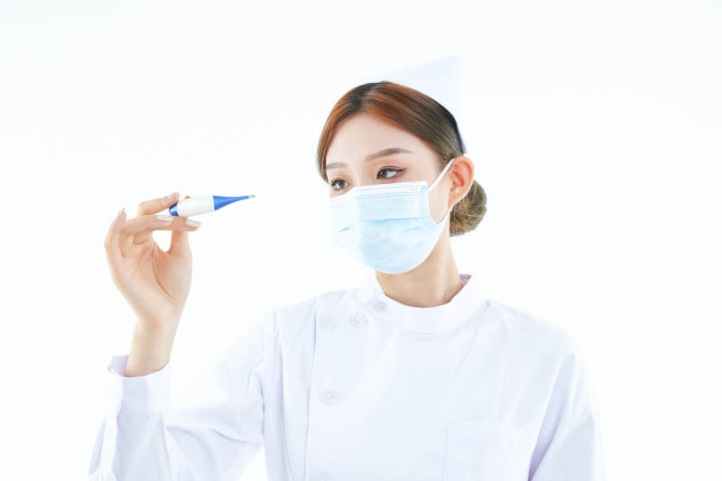 手持温度计的白衣女性医护人员图片
