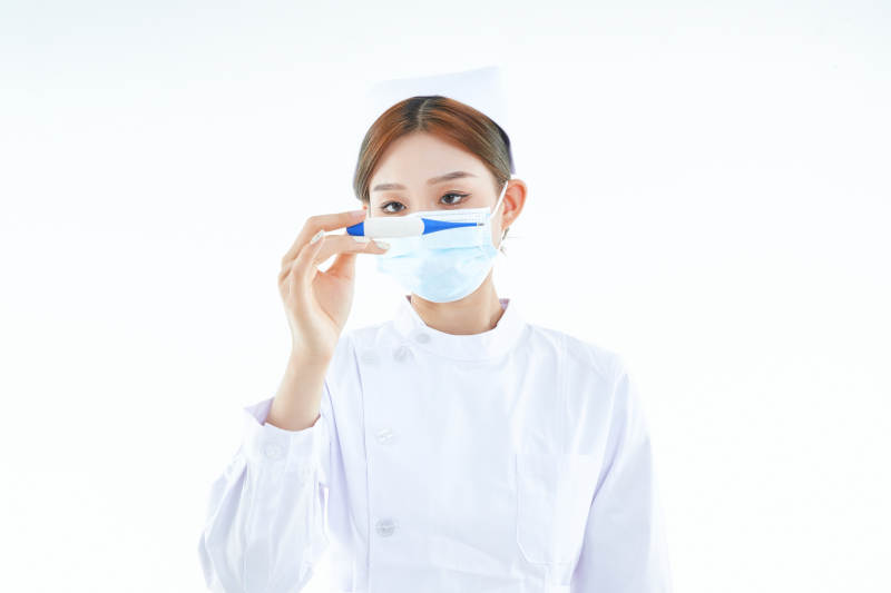 手持温度计的白衣女性医护人员图片