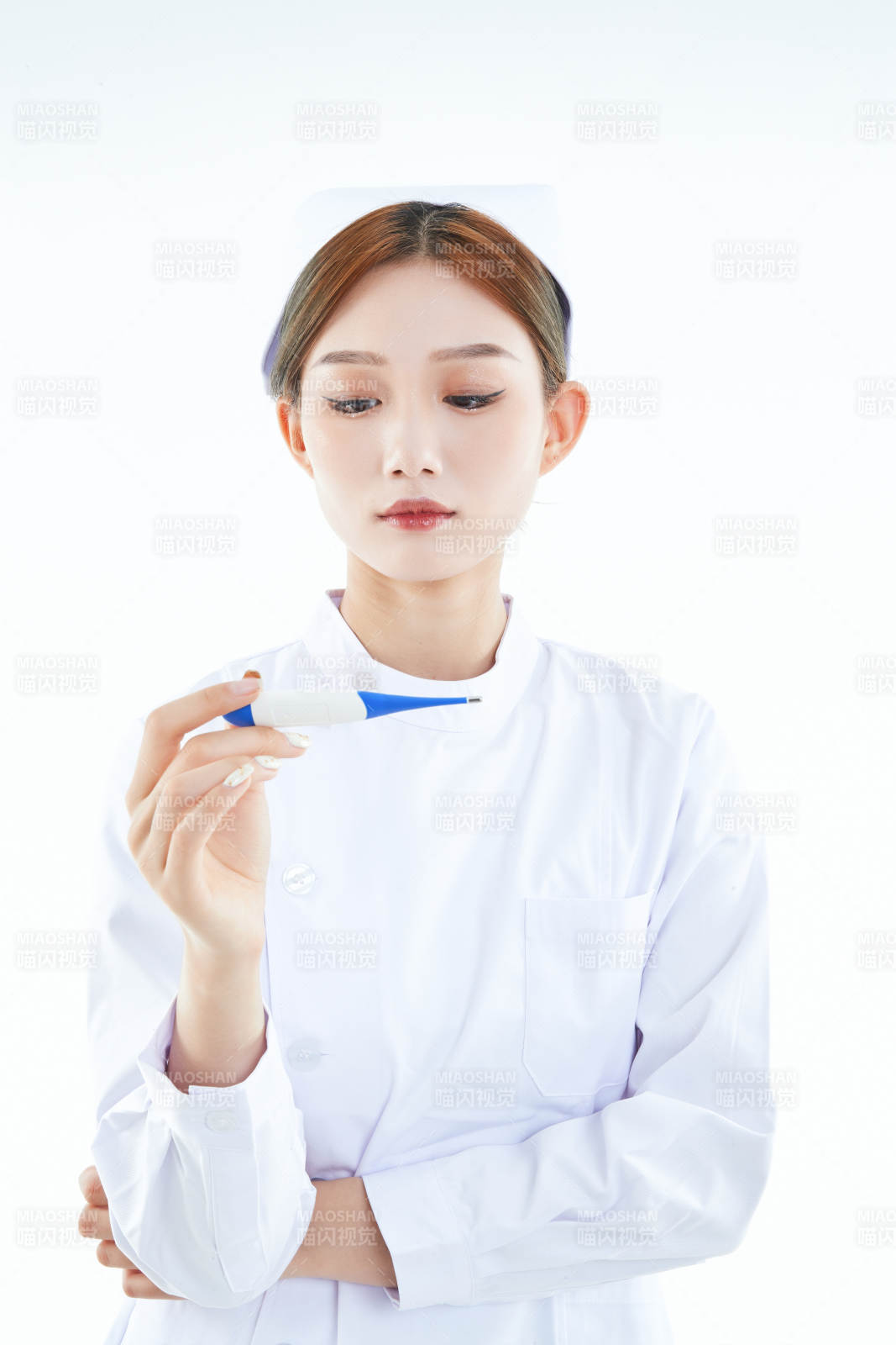 手持温度计的白衣女性医护人员图片