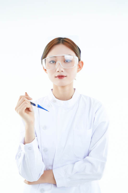 手持温度计的白衣女性医护人员图片