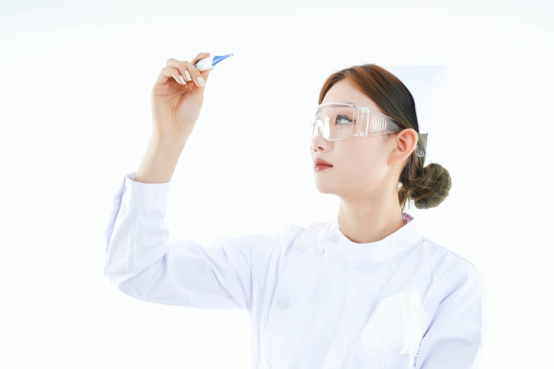手持温度计的白衣女性医护人员图片