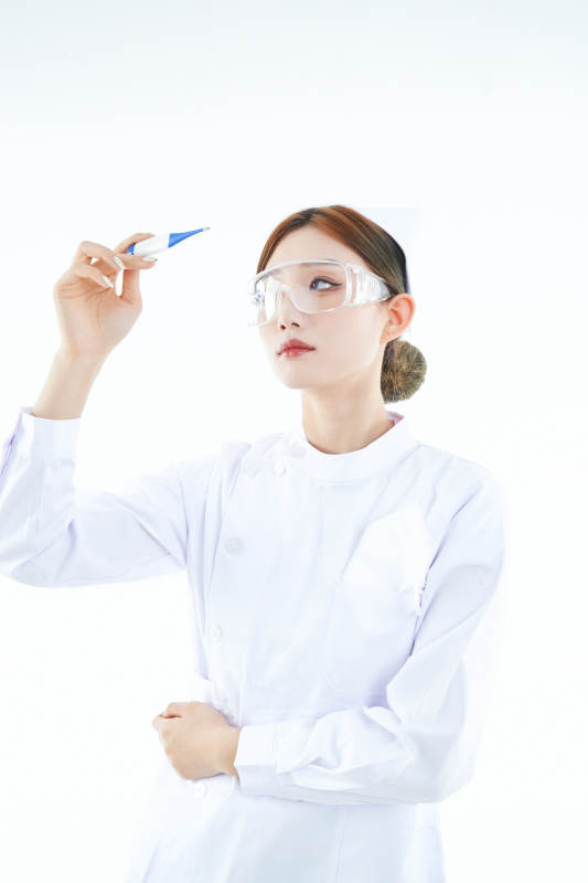 手持温度计的白衣女性医护人员图片