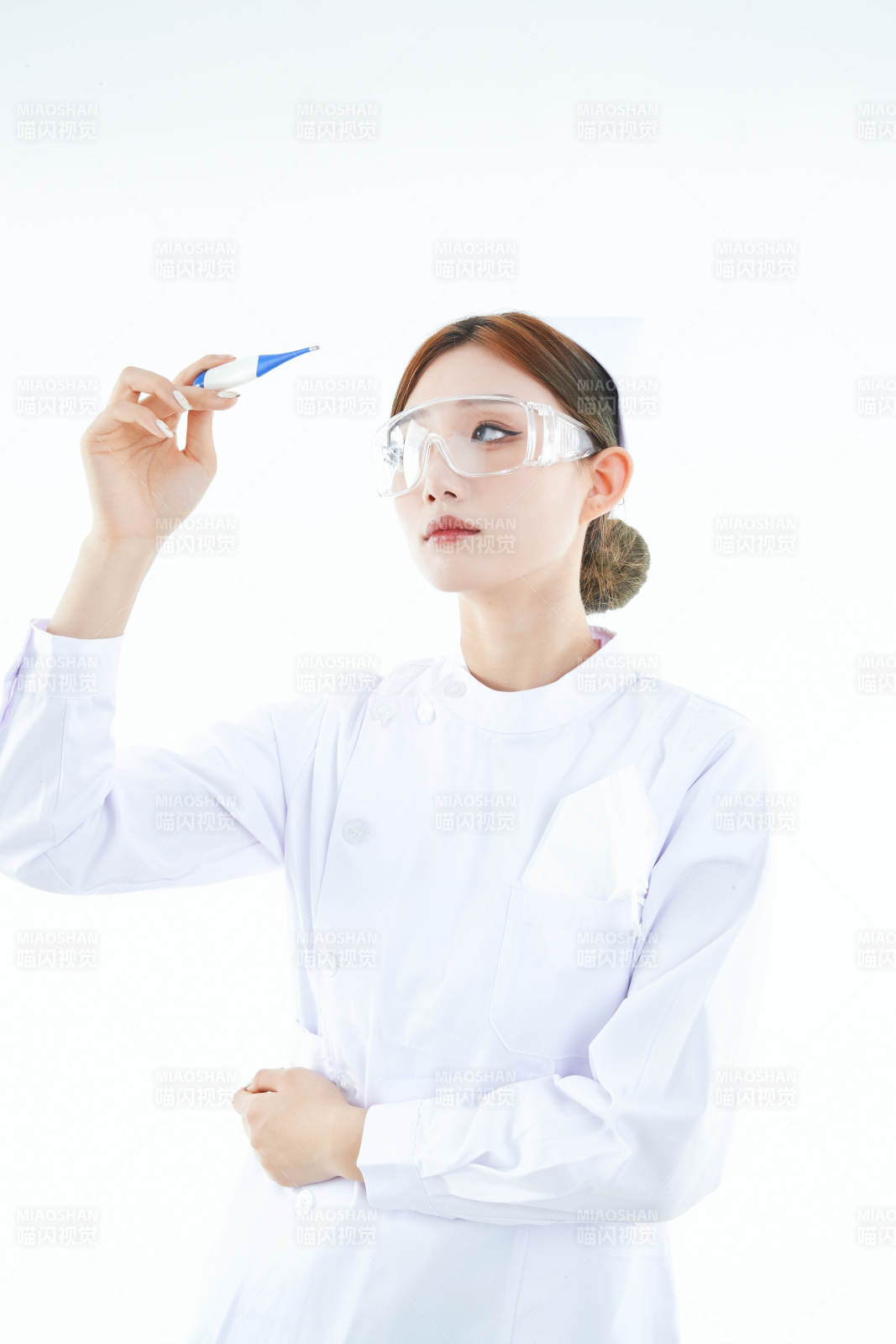 手持温度计的白衣女性医护人员图片