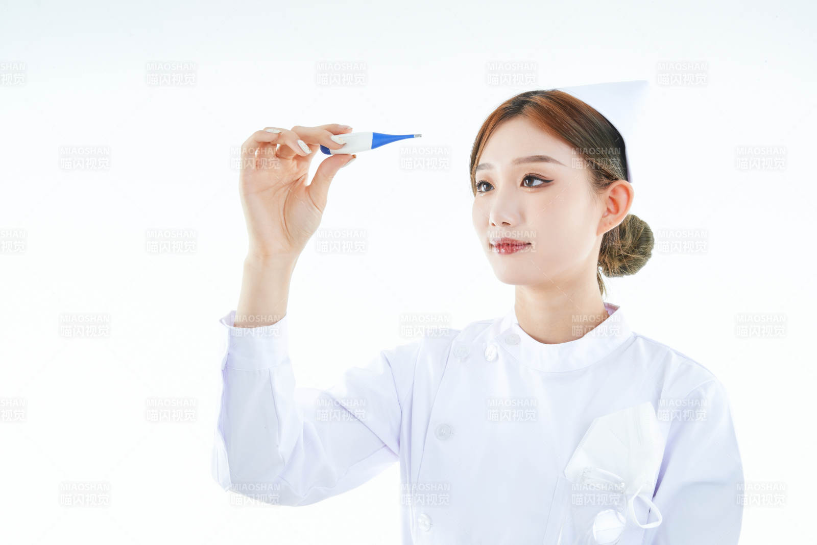 手持温度计的白衣女性医护人员图片