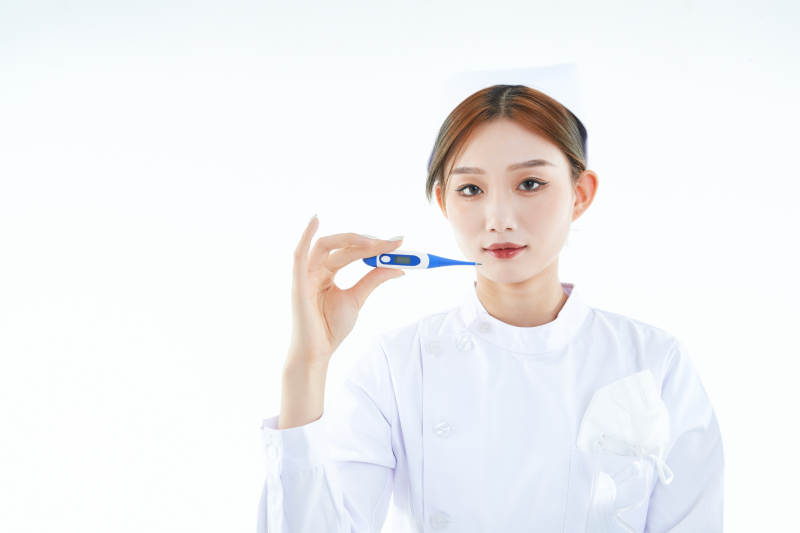 手持温度计的白衣女性医护人员图片