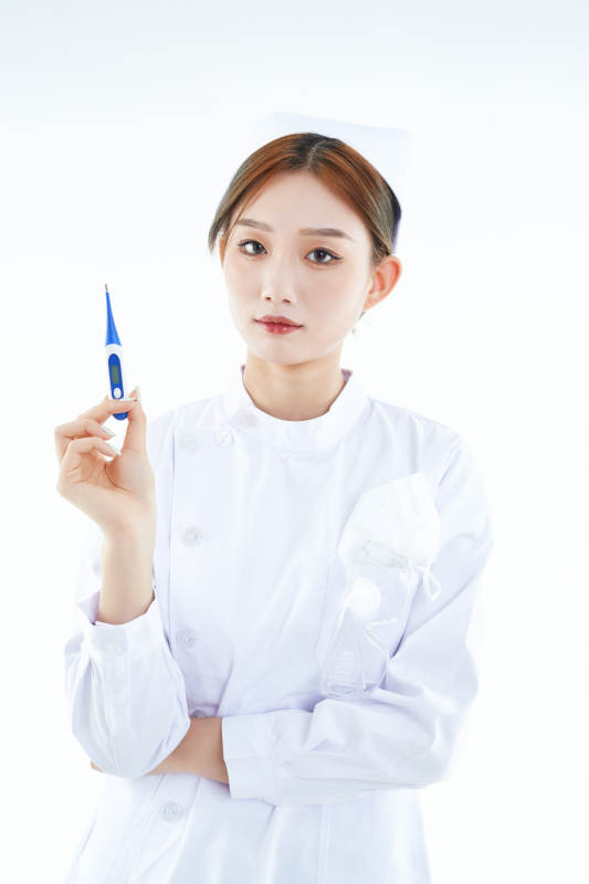 手持温度计的白衣女性医护人员图片
