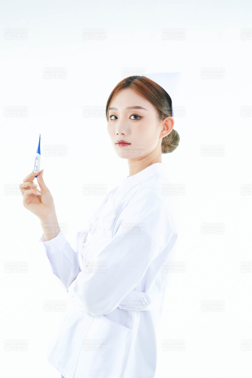 手持温度计的白衣女性医护人员图片
