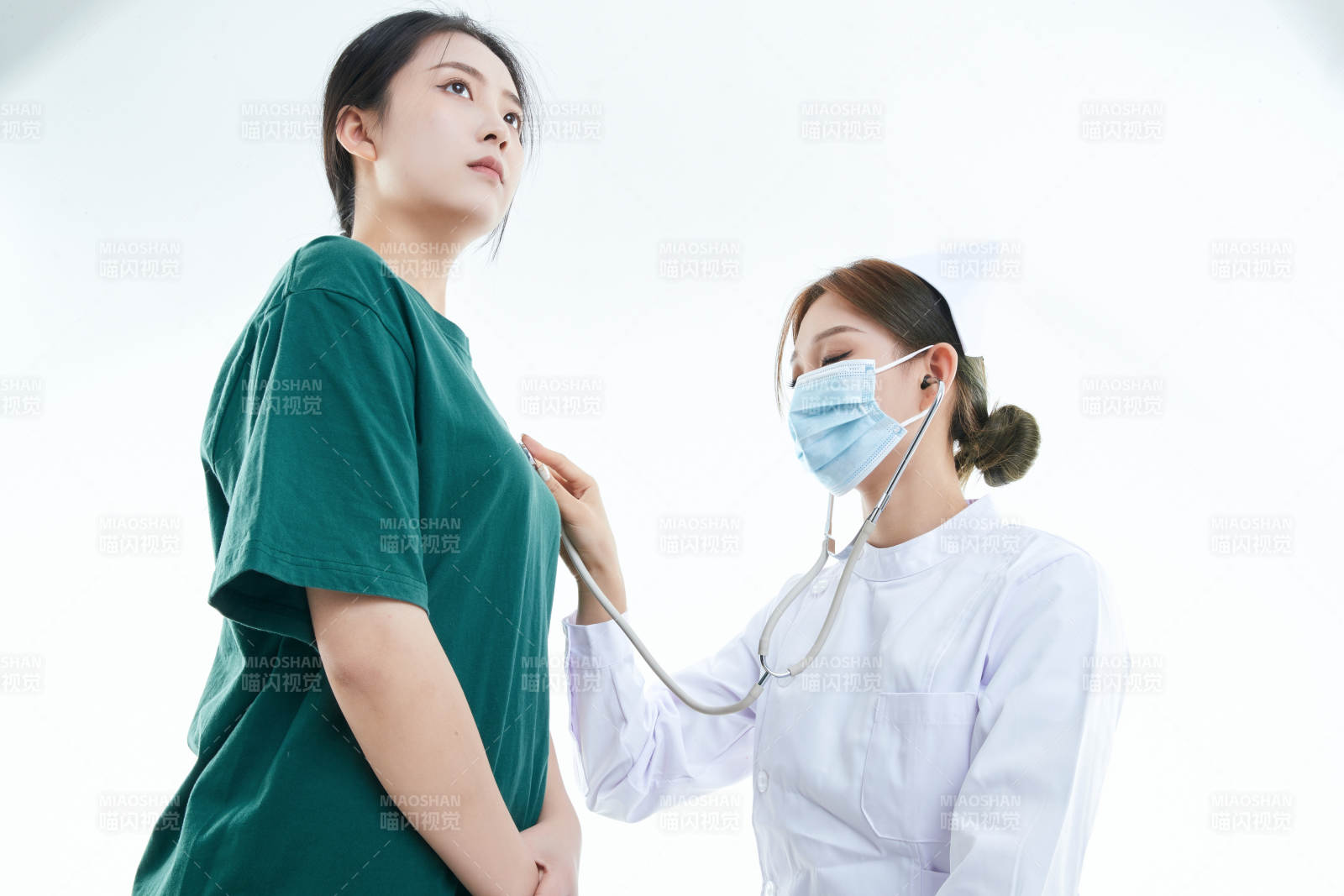 佩戴听诊器的女性医护人员为患者听诊检查图片