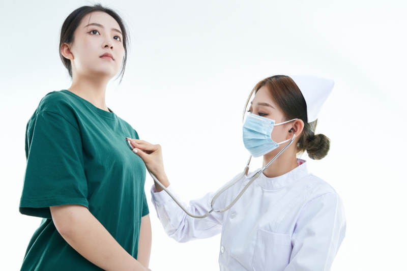 佩戴听诊器的女性医护人员为患者听诊检查图片